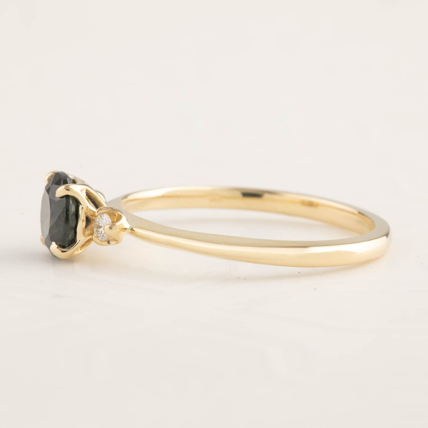 14k yellow gold ring with 1ct dark peacock sapphire and small side diamond in elegant tapered band design