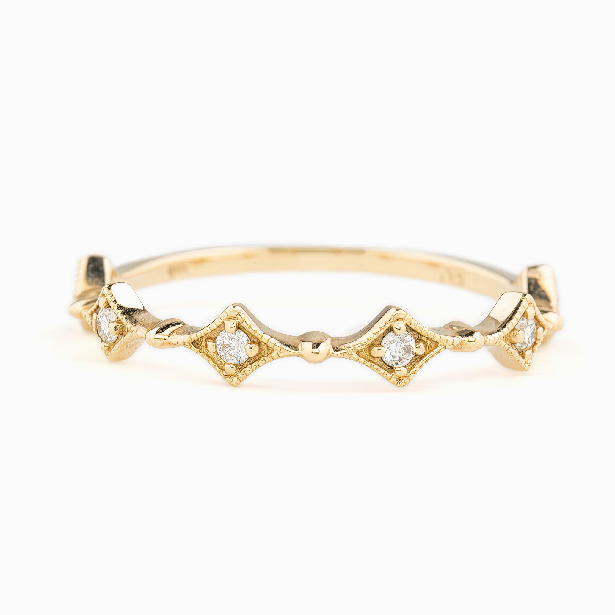 A gold ring with diamond accents in a star pattern design, displayed against a white background.