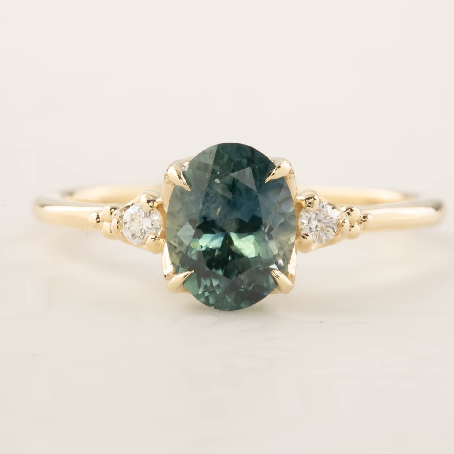 Light blue-green 1.78ct Montana sapphire ring with white diamond accents in recycled 14k yellow gold band