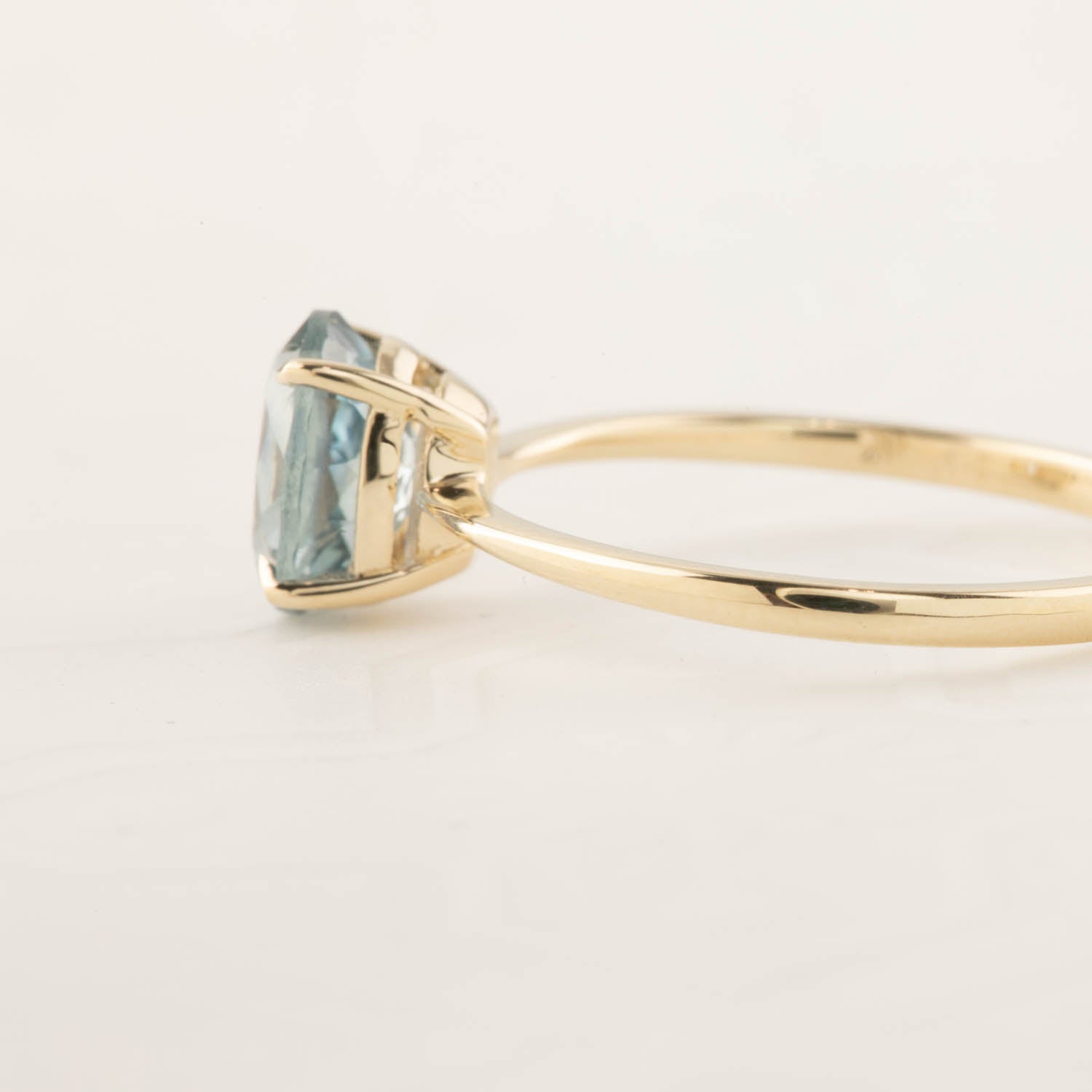 Side view of Nina Ring with 1.4ct light blue Montana Sapphire in 14k yellow gold tapered band