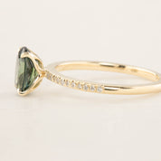 Close-up of 14k yellow gold ring with 1.53ct oval green Queensland sapphire and small accent diamonds on band