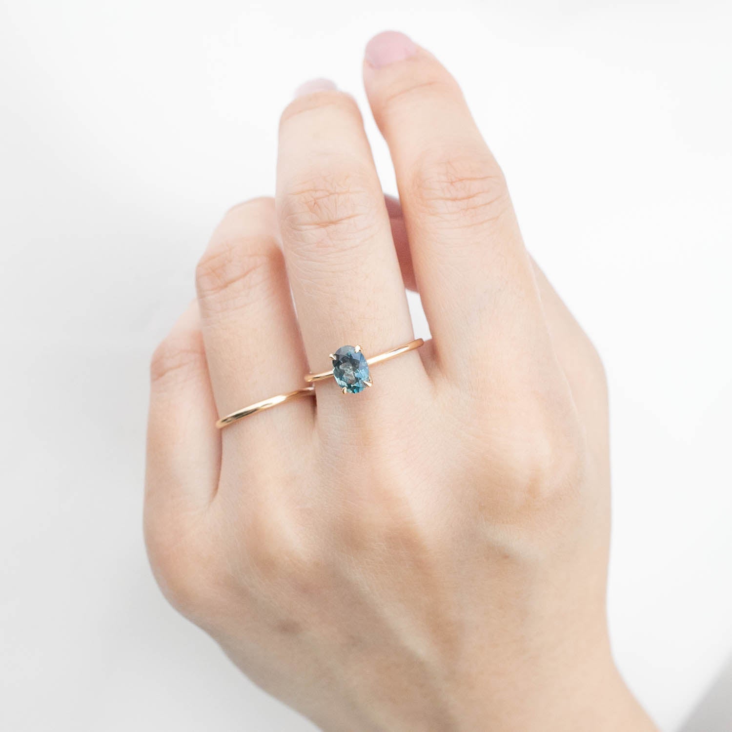 Hand wearing one of a kind Sara Ring with 1.32ct blue Montana sapphire set in 14k yellow gold band
