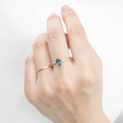 Hand wearing one of a kind Sara Ring with 1.32ct blue Montana sapphire set in 14k yellow gold band