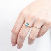 Hand wearing Estel Ring with 1.78ct light blue-green Montana sapphire set in 14k yellow gold band
