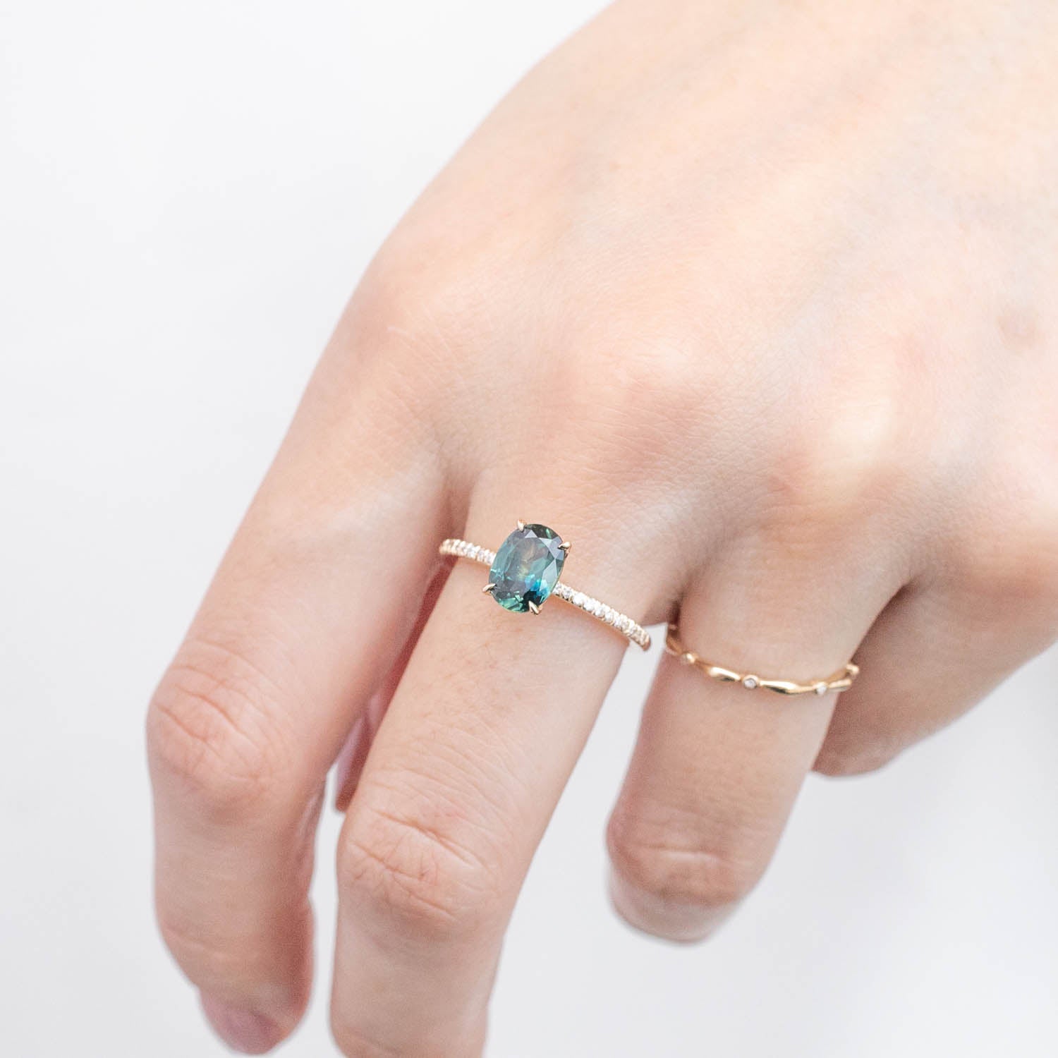 Hand wearing Maria Ring with 1.53ct unheated oval green Queensland sapphire set in 14k yellow gold band