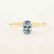 Close-up of a 0.98ct oval blue Montana sapphire ring set in recycled 14k rose gold with a tapered band