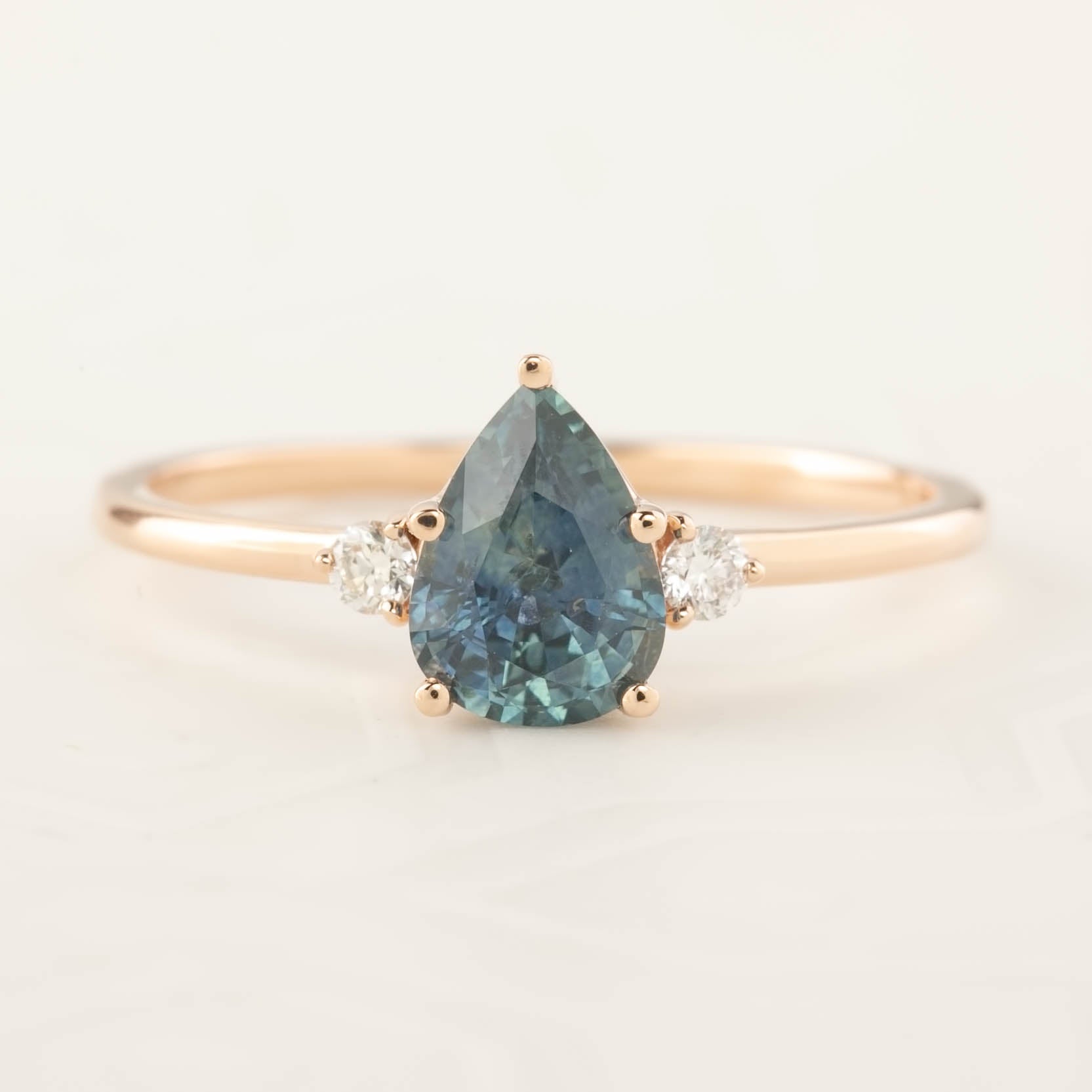 Emilie Ring featuring a 1.07ct pear cut blue-green Montana sapphire with diamonds in 14k rose gold, handmade and unique.