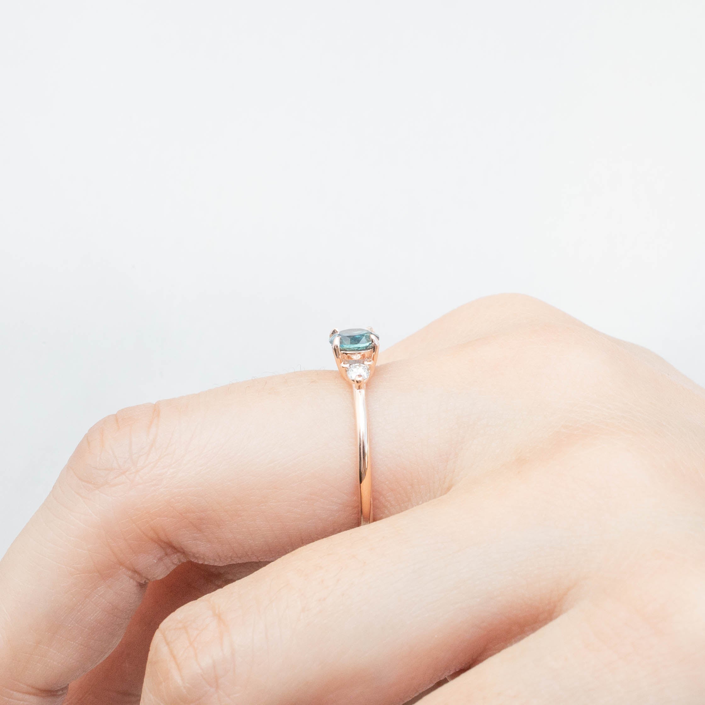 Emilie Ring featuring 0.66ct blue-green Montana sapphire set in 14k rose gold with diamond accents, handmade and unique.
