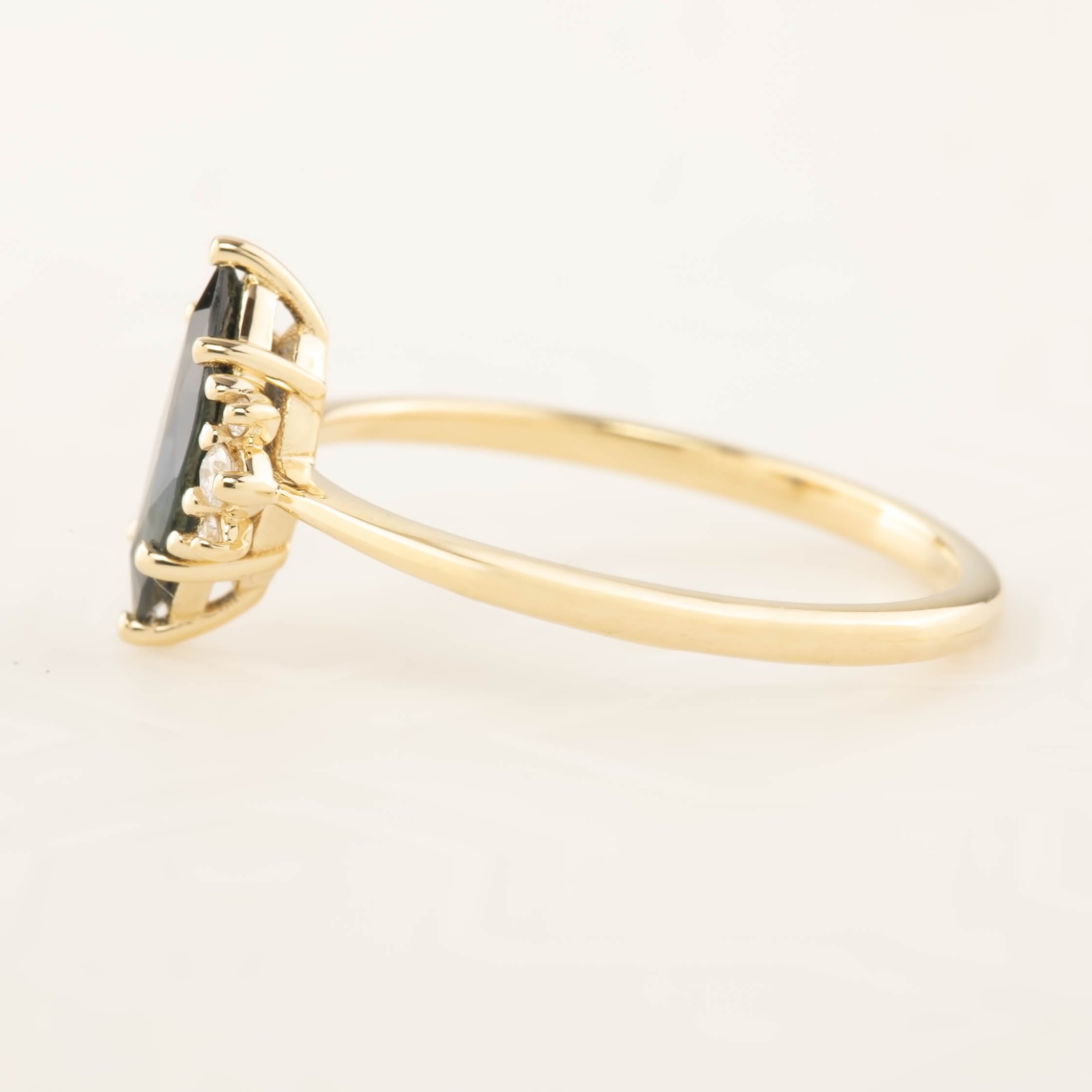 Lena Ring featuring a 0.94ct marquise dark blue green sapphire with white accent diamonds in 14k gold, handmade and ethical.