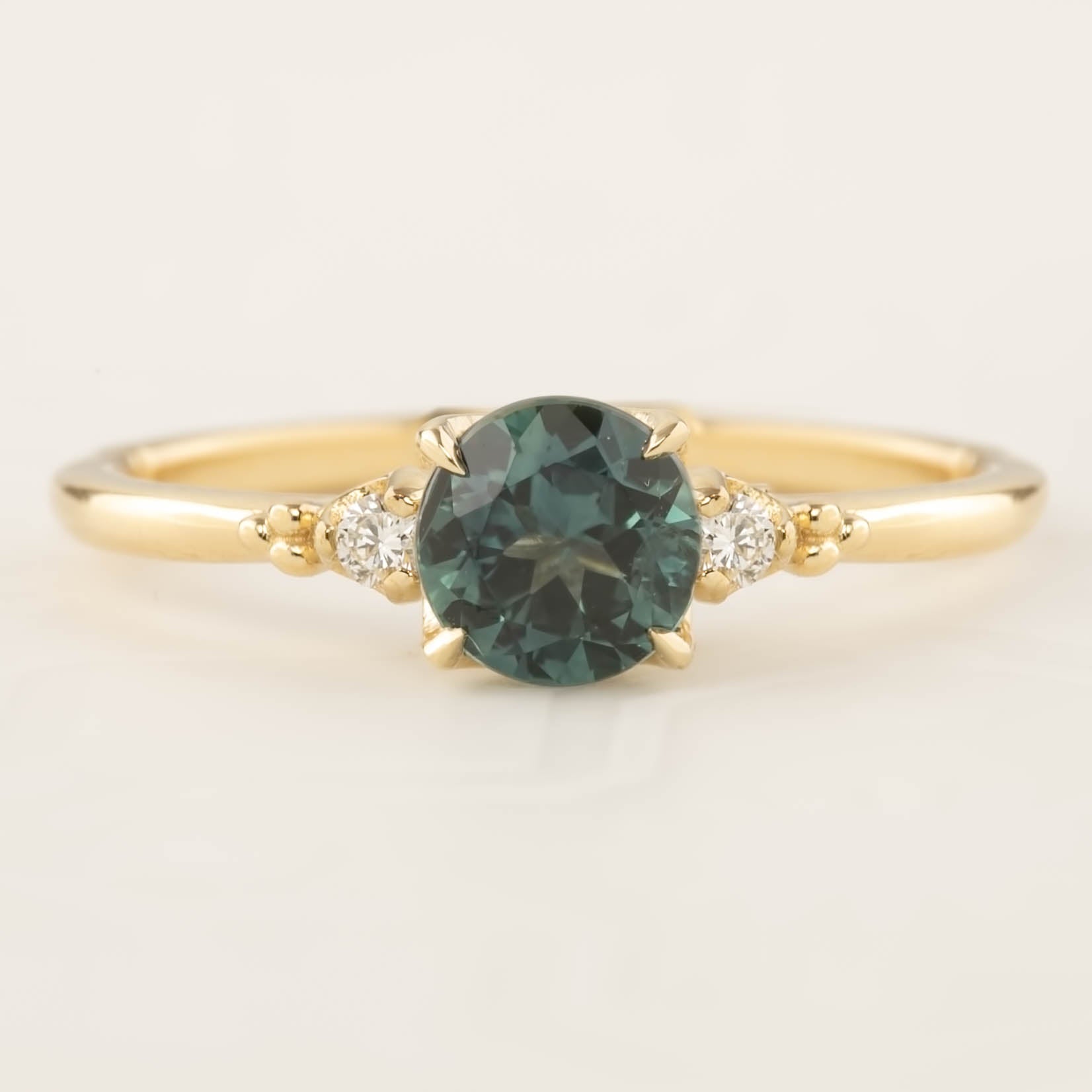 Estel Ring featuring a 0.94ct peacock green Queensland sapphire with white diamond accents in 14k gold band