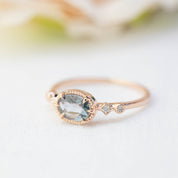 Rose gold ring with 0.8ct blue sapphire and small white diamonds in a delicate bezel setting