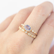 Close-up of hand wearing a 0.8ct blue sapphire Stella ring in 14k rose gold with diamond accents
