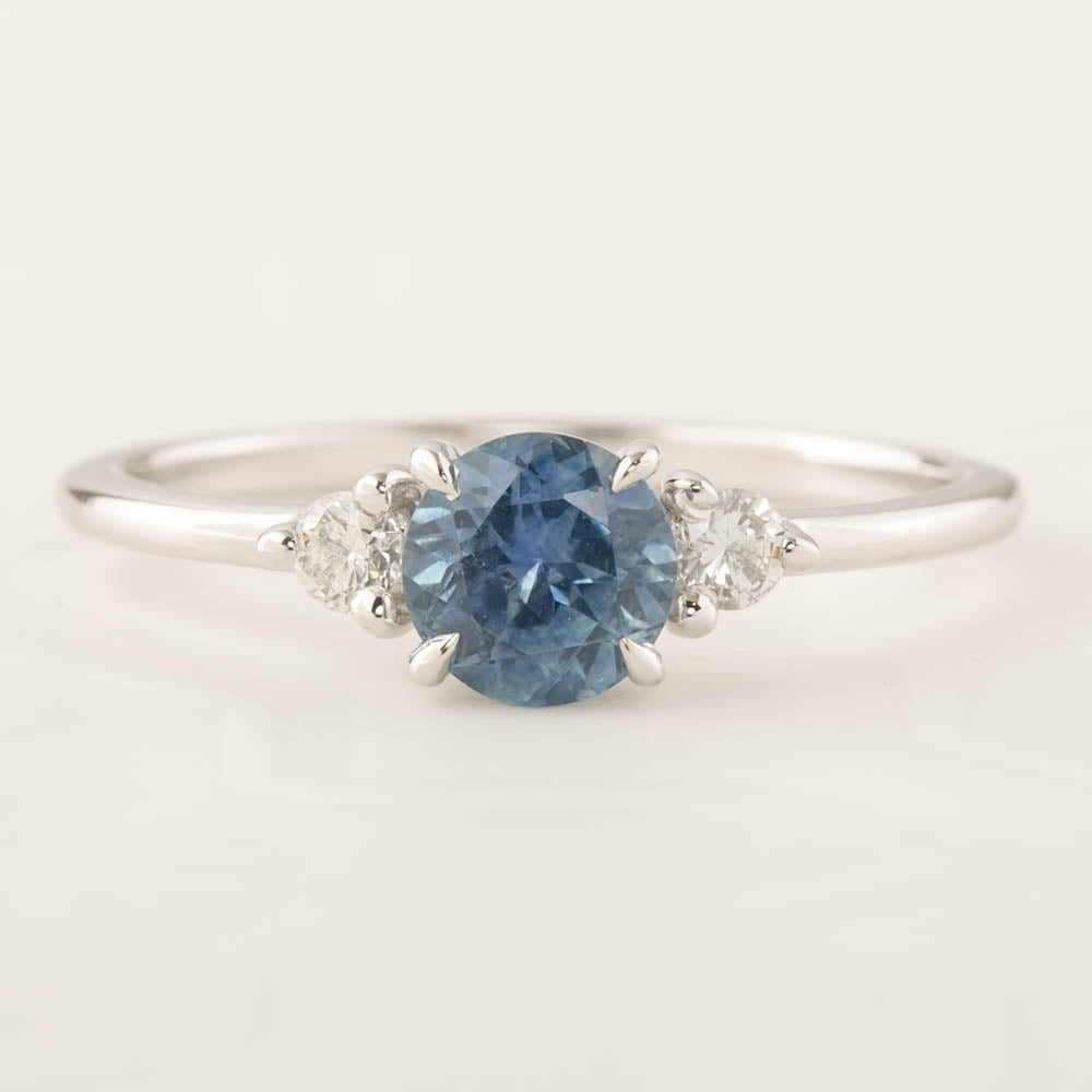 Emilie Ring featuring a 0.84ct blue Montana sapphire and two diamonds in recycled 14k white gold band