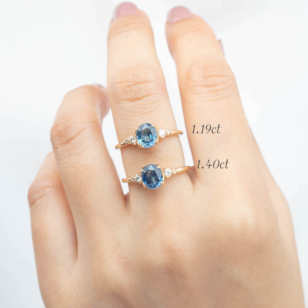 Hand wearing two handcrafted Estel Rings with blue sapphires and diamond accents in recycled 14k gold settings