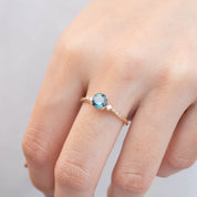 Estel Ring with 0.94ct peacock green Queensland sapphire and white diamonds in recycled 14k gold band.