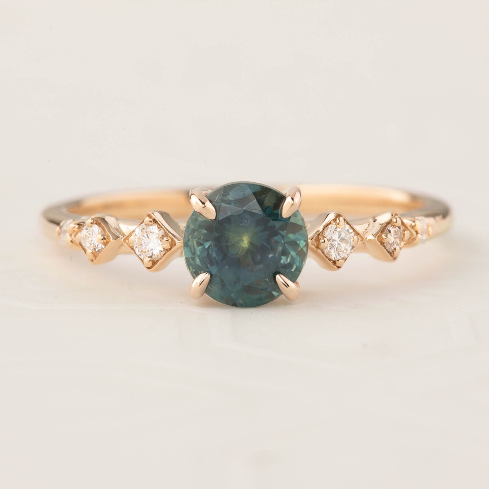 Celeste Ring featuring a 1.19ct teal blue Montana sapphire with accent diamonds in 14k rose gold, handmade and authentic.