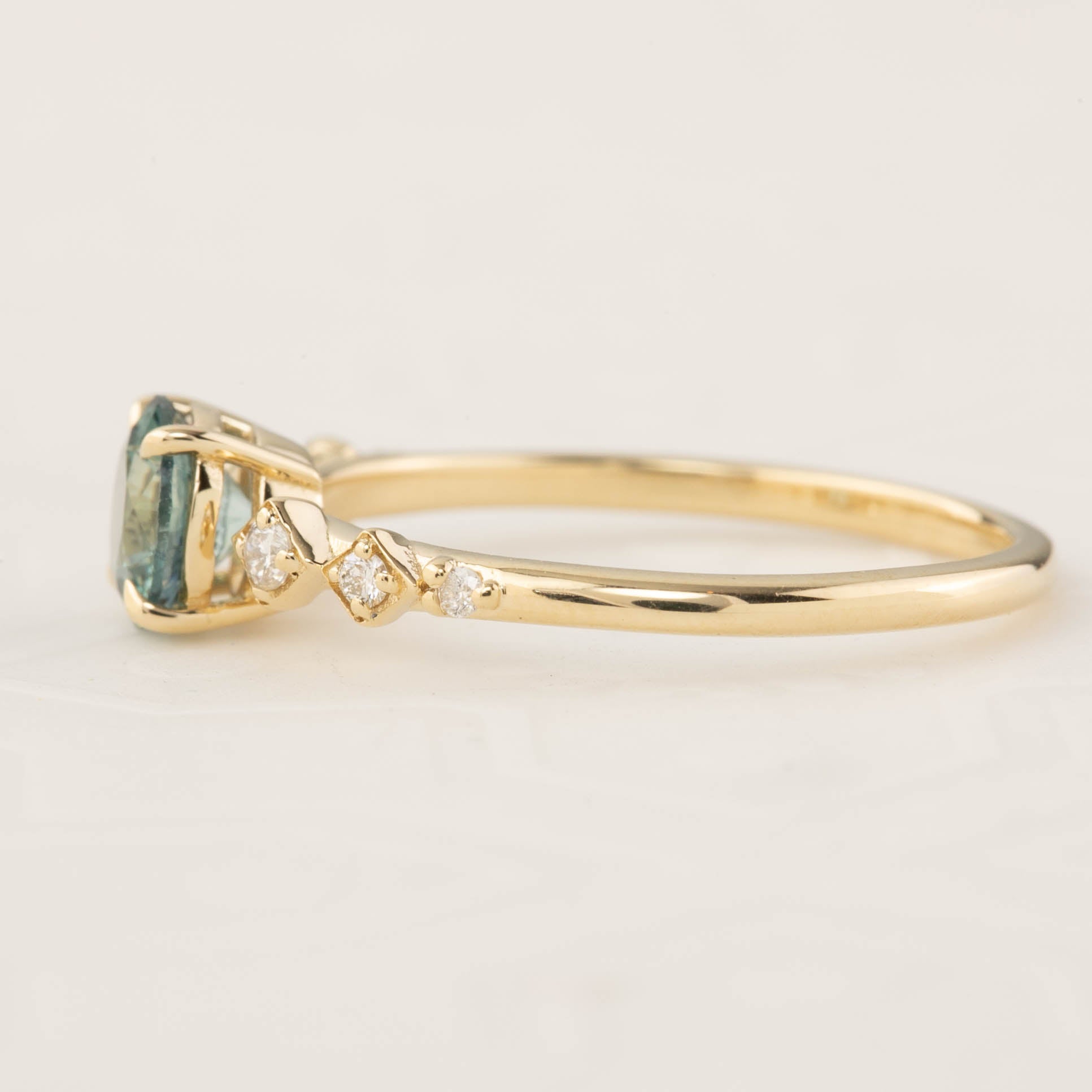 Celeste Ring with 0.89ct blue green Montana sapphire and accent diamonds in recycled 14k yellow gold band
