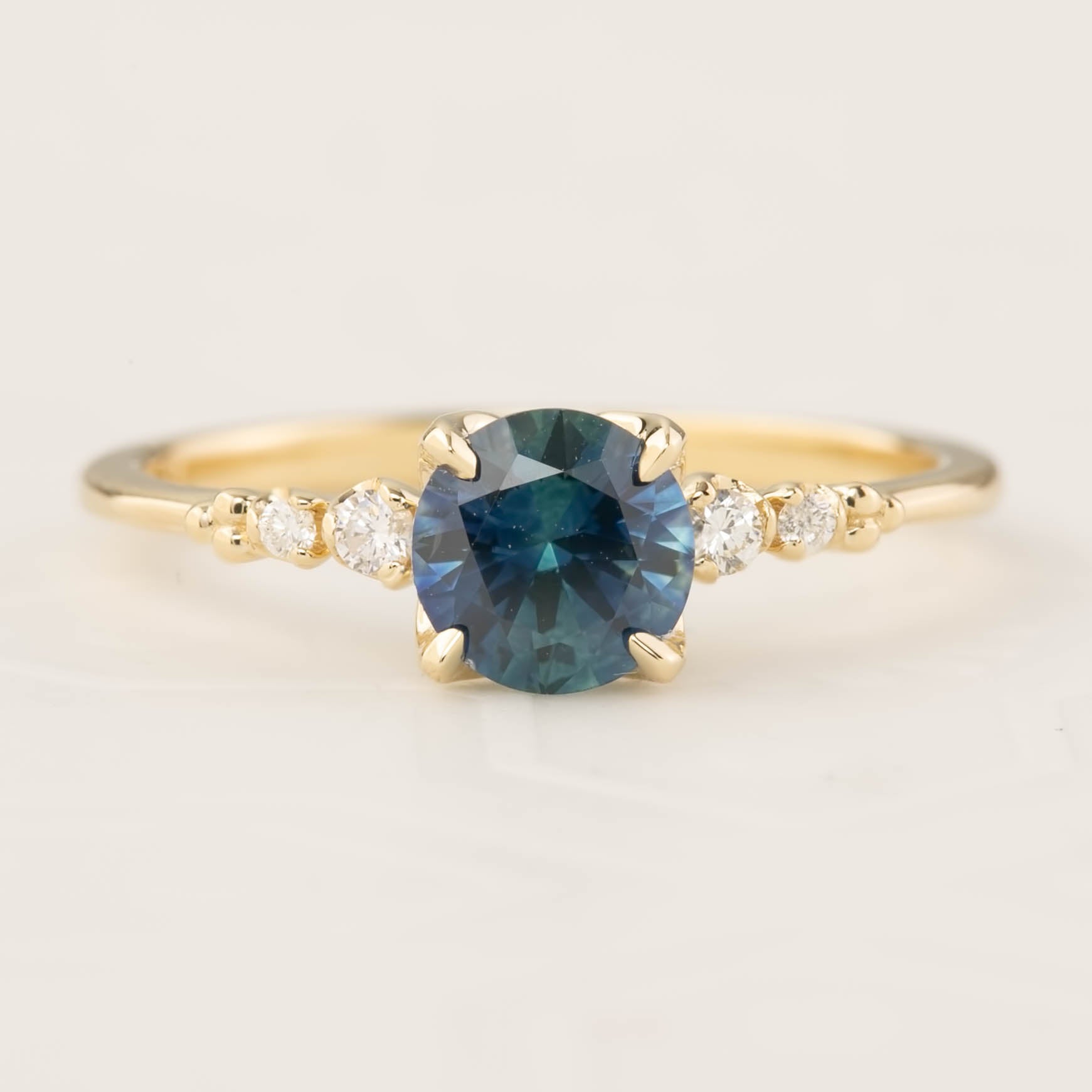 Estel Luxe Ring featuring a 0.96ct teal blue Montana sapphire with white diamond accents in 14k gold band