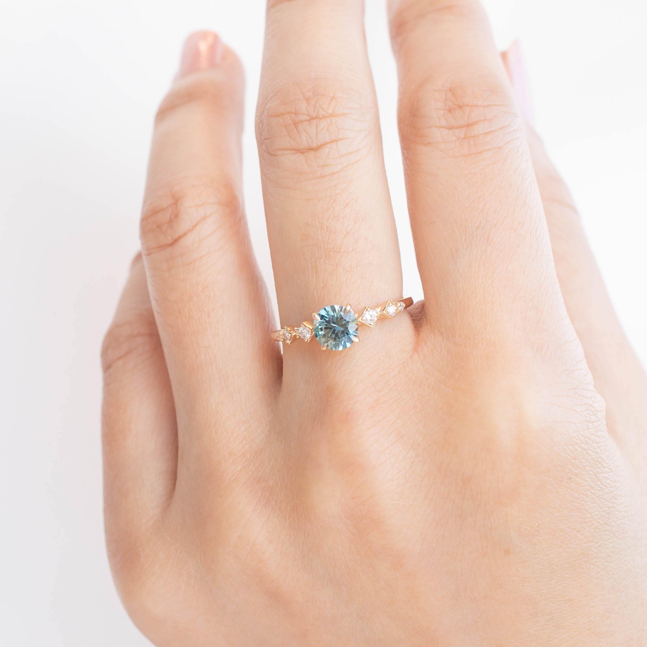 Celeste Ring with 0.89ct blue-green Montana sapphire and accent diamonds, handmade in recycled 14k yellow gold.