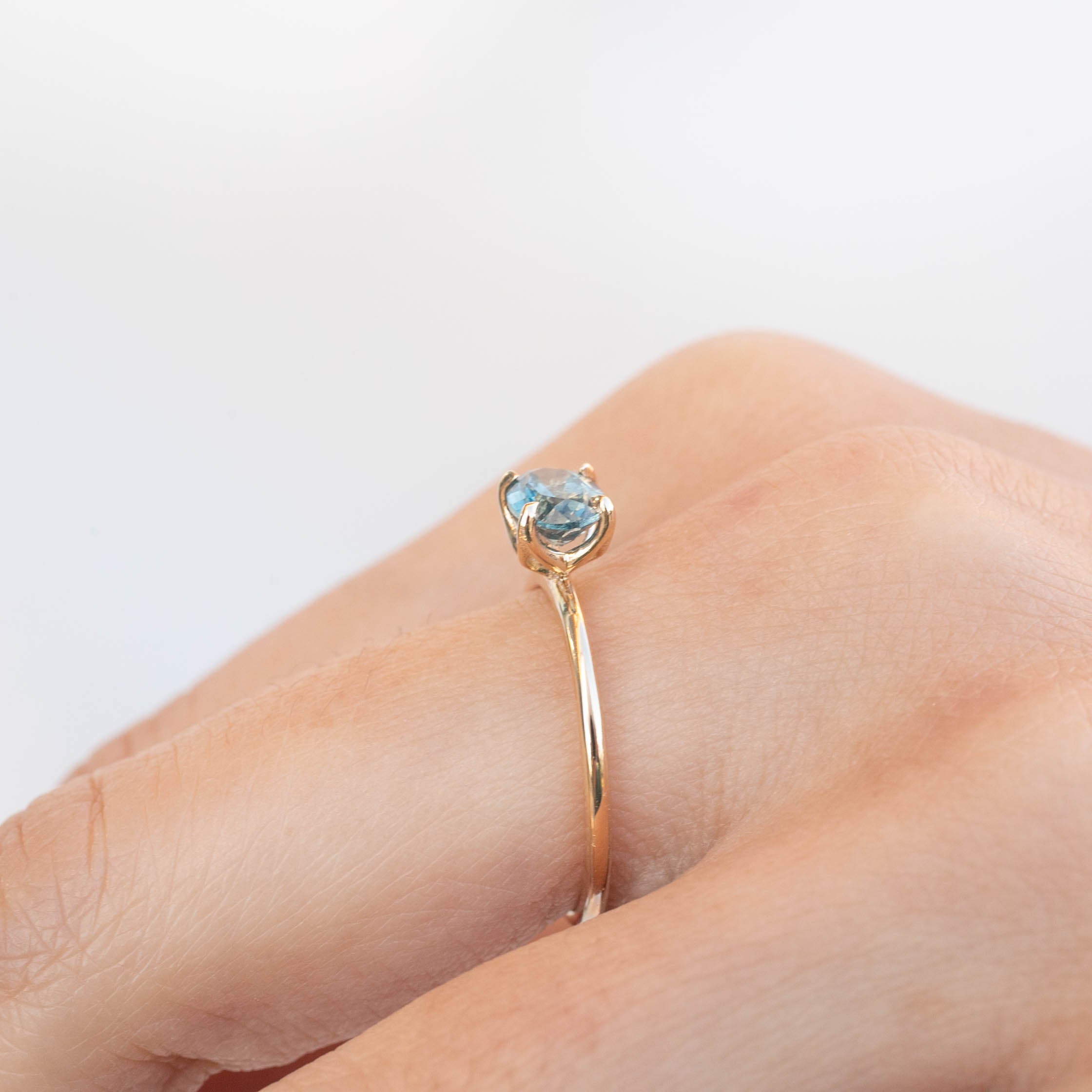 Sara Ring with 1.05ct blue-green Montana sapphire, handmade, ethically sourced, 14k recycled gold band on finger