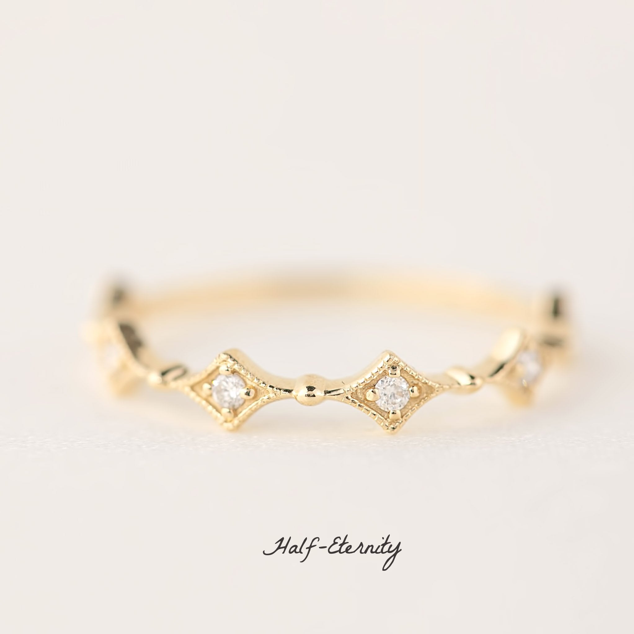 Gold eternity ring with natural white diamonds in star-shaped settings, delicate and ethically sourced design