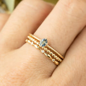 The Alice sapphire ring stacked with different gold bands to show its dainty, minimalist profile.