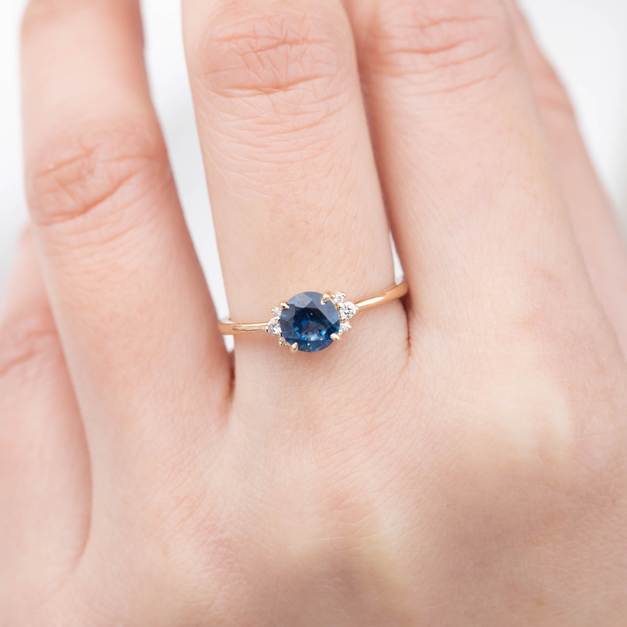 Stunning Lena Ring featuring a 1.18ct blue Montana sapphire, set in 14k yellow gold with sparkling white diamonds.