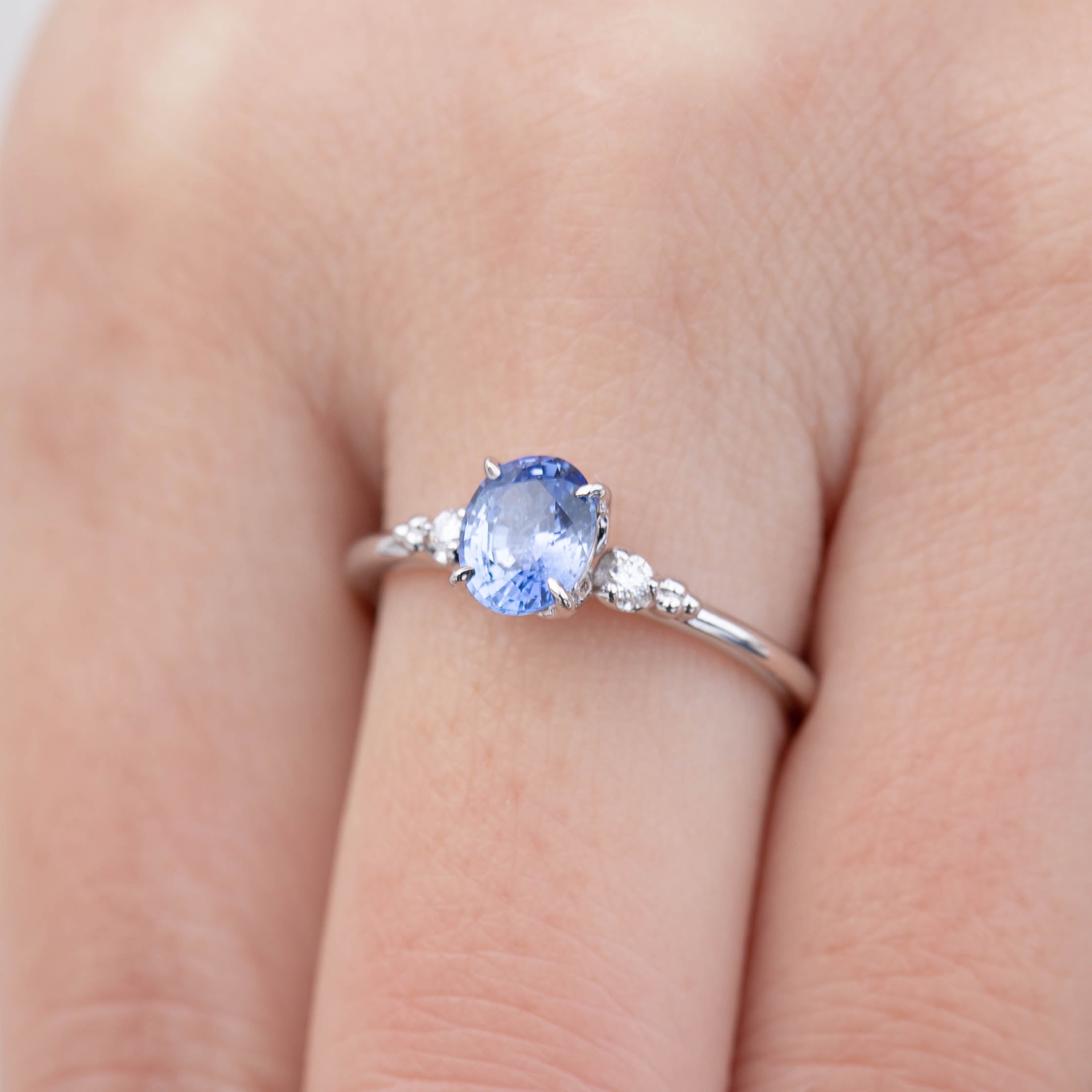 14k white gold ring with 1.01ct blue Ceylon sapphire and white accent diamonds on finger, size 7