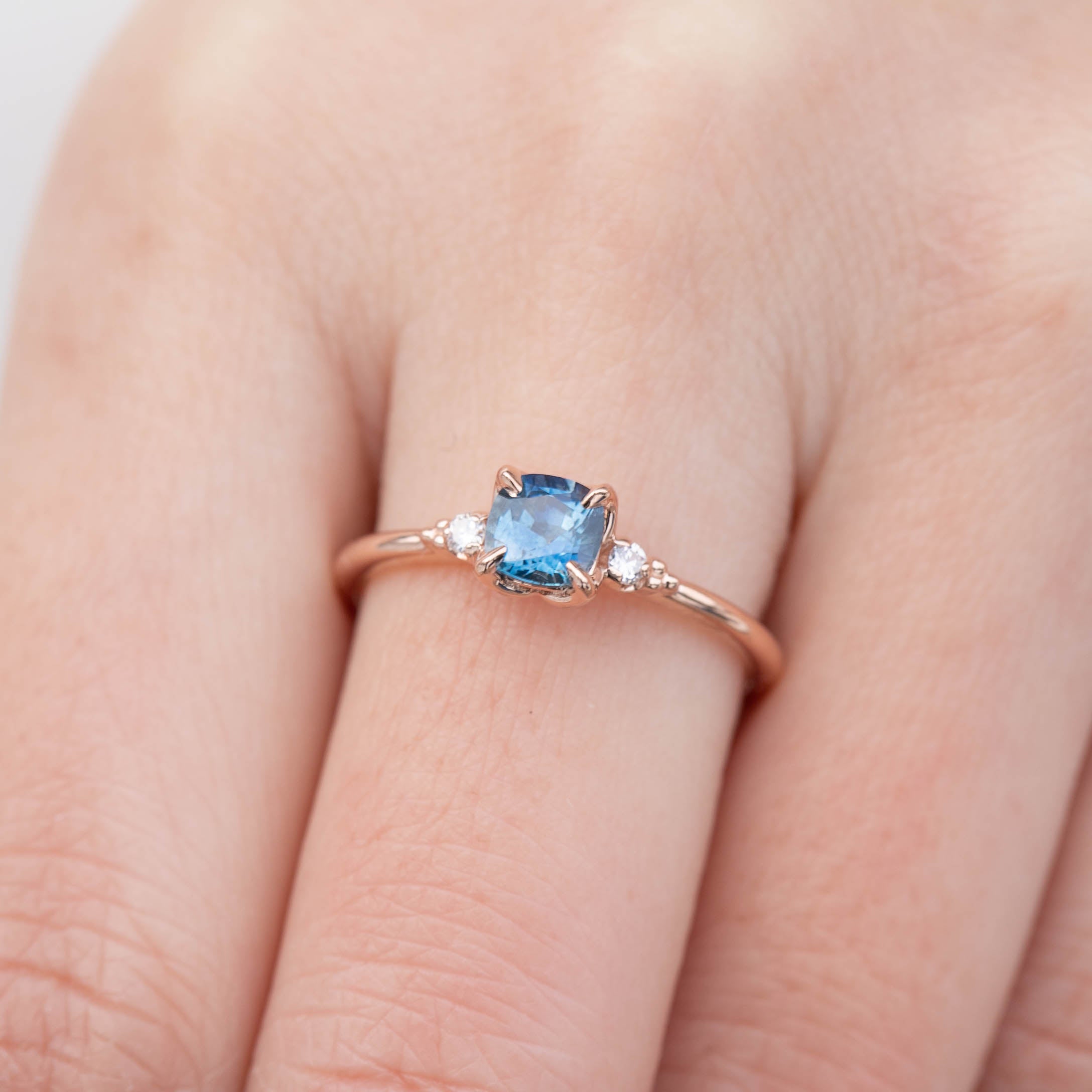 Close-up of Estel Ring featuring 0.76ct cushion Montana sapphire with diamond accents in 14k rose gold band