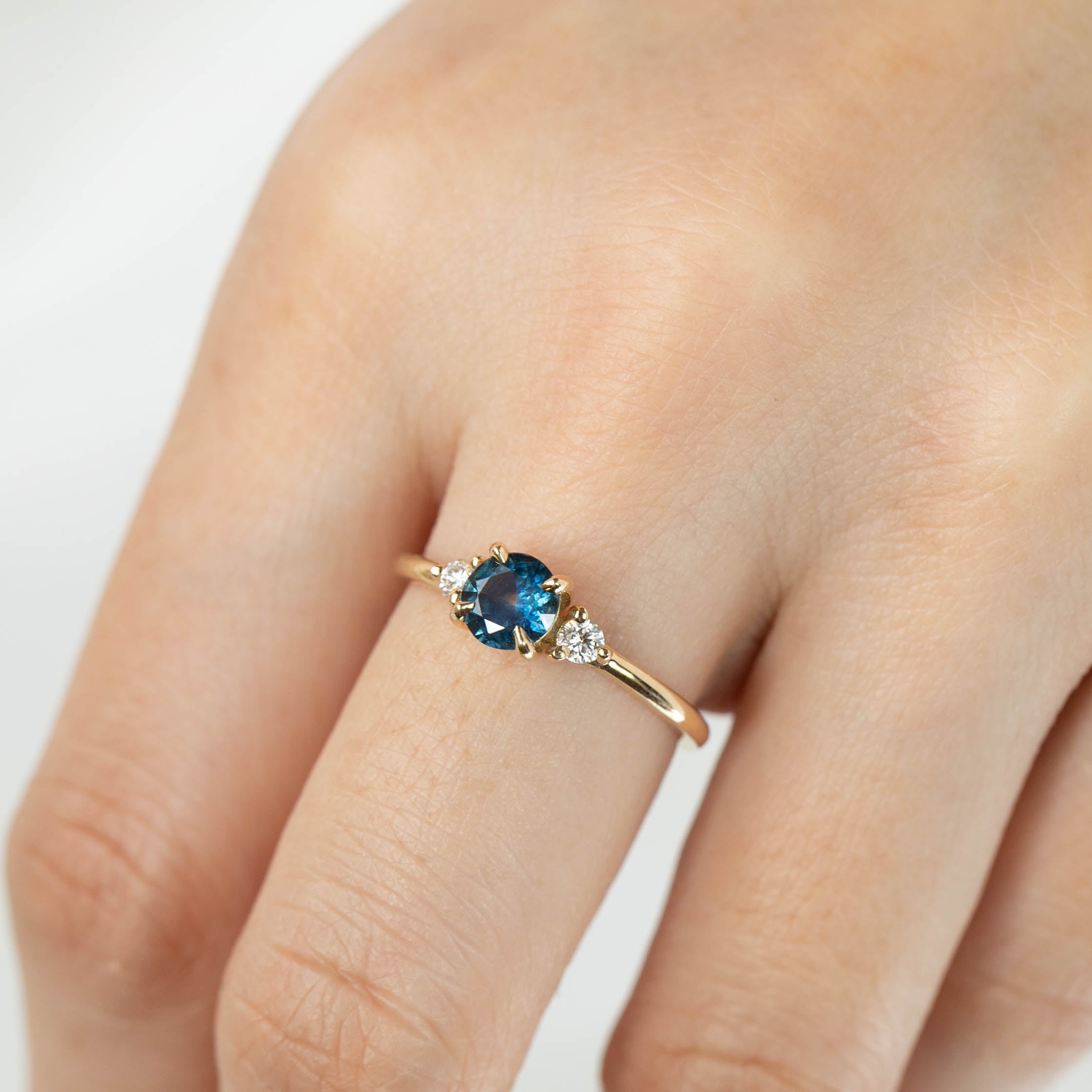 Emilie Ring featuring 0.71ct blue green Montana sapphire set in recycled 14k yellow gold with accent diamonds.