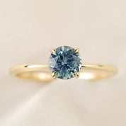 Close-up of Nina Ring featuring 0.94ct light blue Montana Sapphire in 14k yellow gold classic four-prong setting