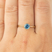 0.94ct light blue Montana sapphire ring in 14k recycled yellow gold with classic 4-prong setting on finger