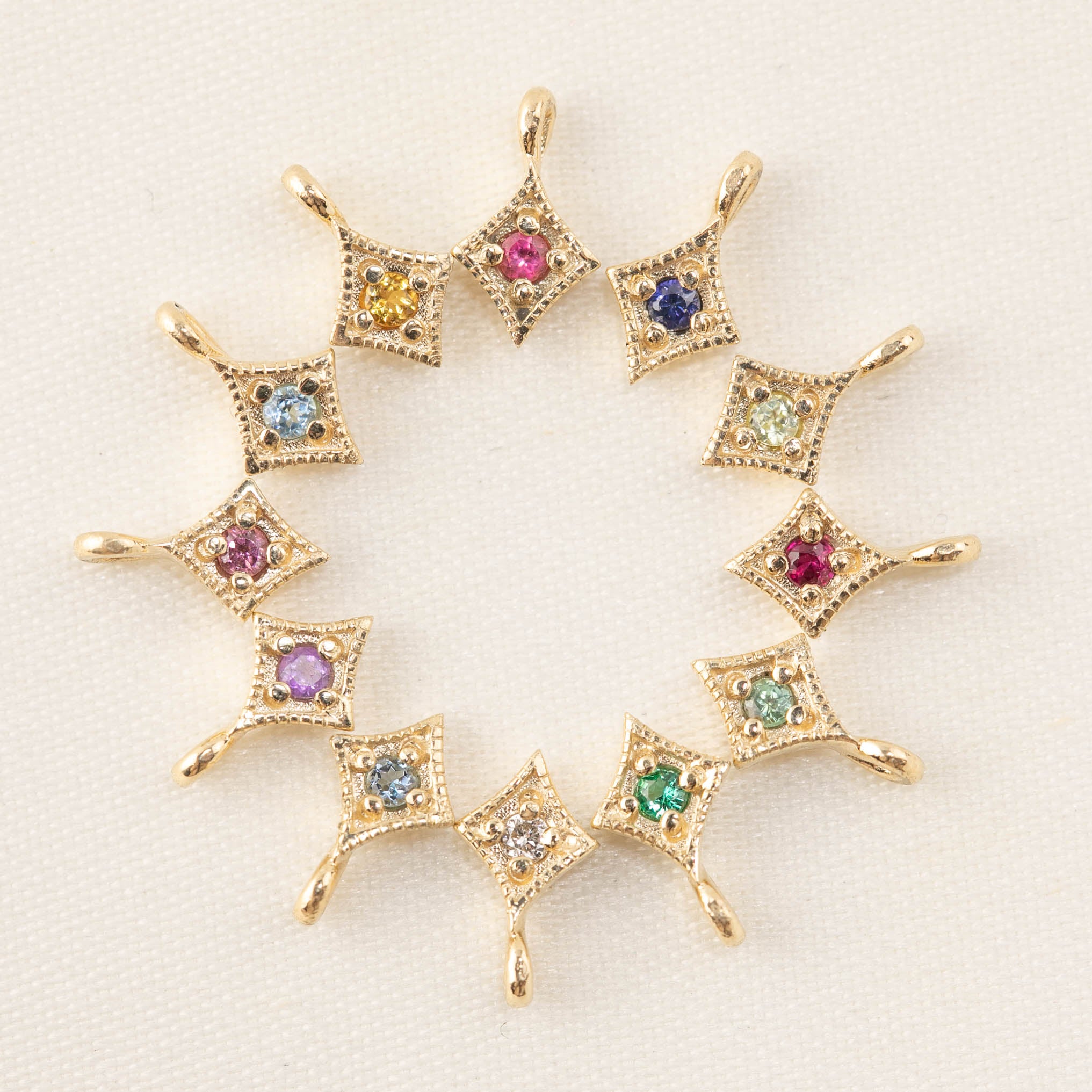 Circle of 14k gold star charms with various genuine birthstone gemstones in bezel settings for necklace customization.