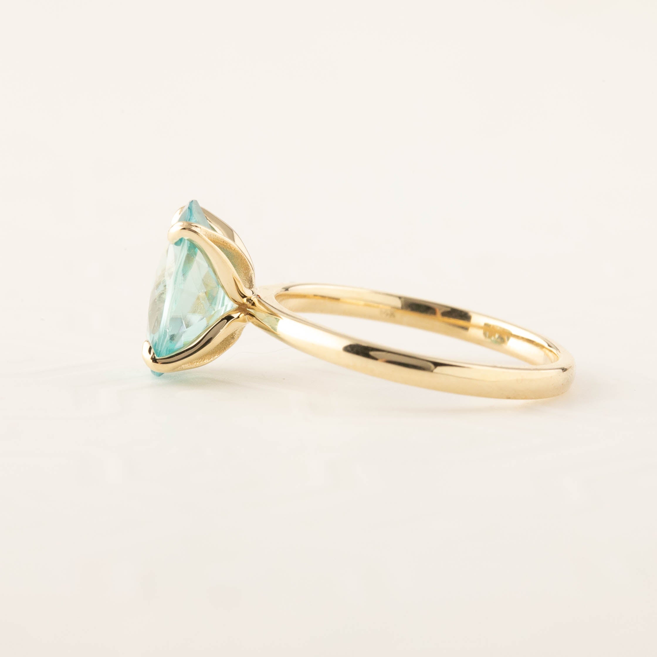 Side view of Sara Ring featuring 4ct blue zircon checkerboard cut set in 14k yellow gold band