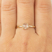Close-up of Lisa Ring featuring a 0.88ct white sapphire set in recycled 14k gold on a finger.