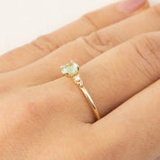 Gold ring with 4.5mm cushion cut natural mint tourmaline and small brilliant cut diamond on finger