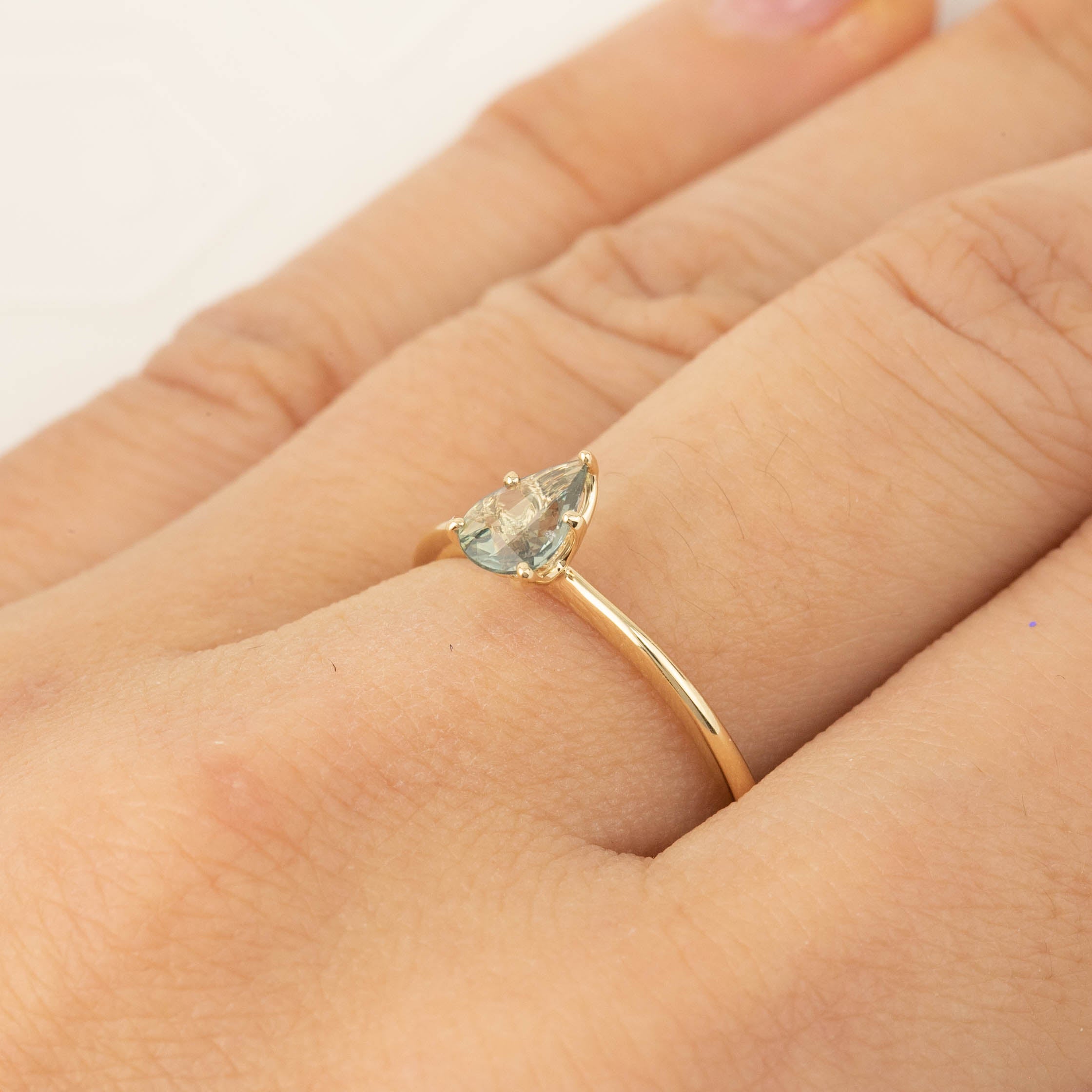 Delicate 14k yellow gold ring with 0.50ct unheated Madagascar sapphire in five-prong floral setting on finger