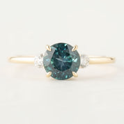Three stone ring featuring a 1.48ct green Montana sapphire with diamond accents in 14k gold setting