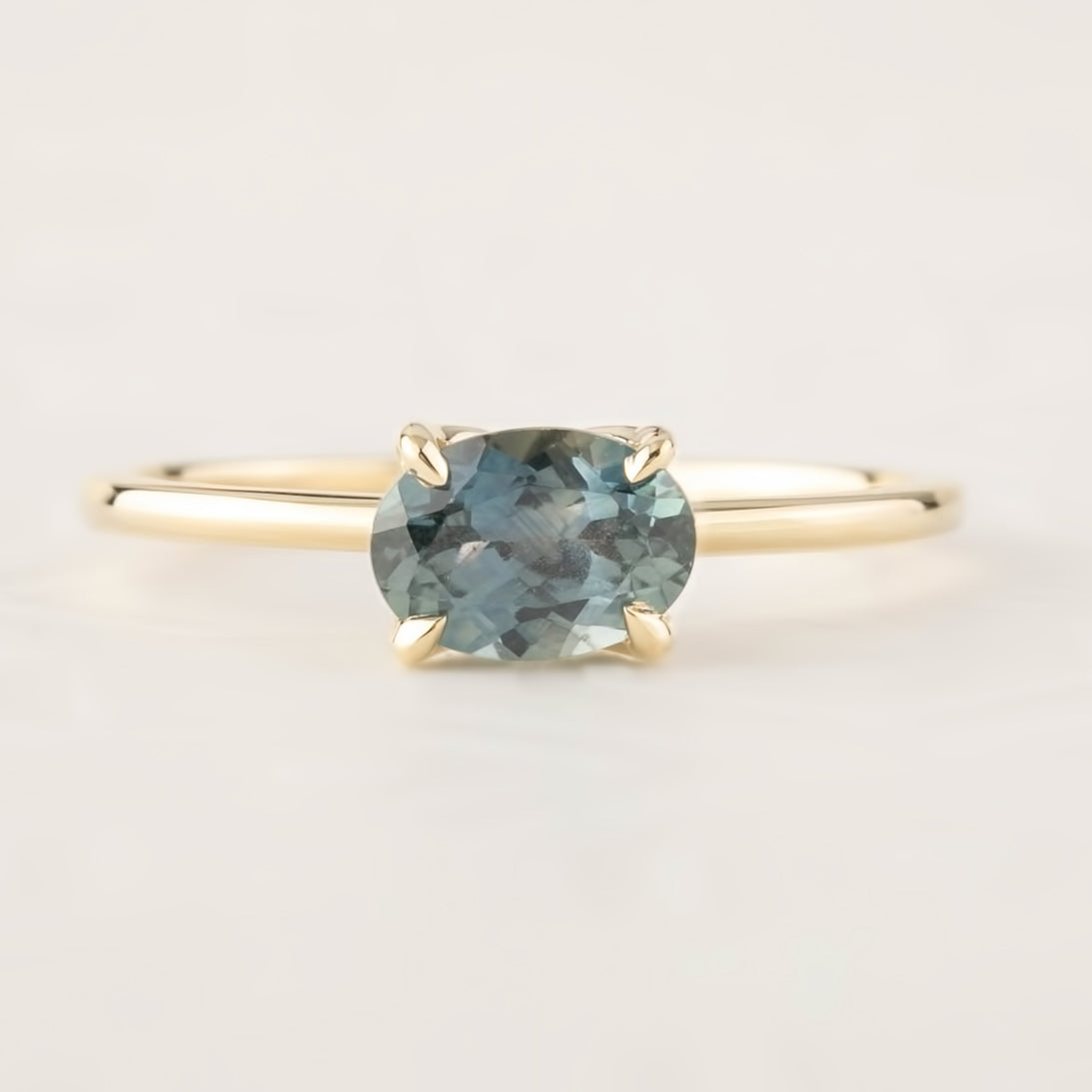 14k yellow gold ring with 1.12ct light blue-green Montana sapphire in a classic four-prong setting