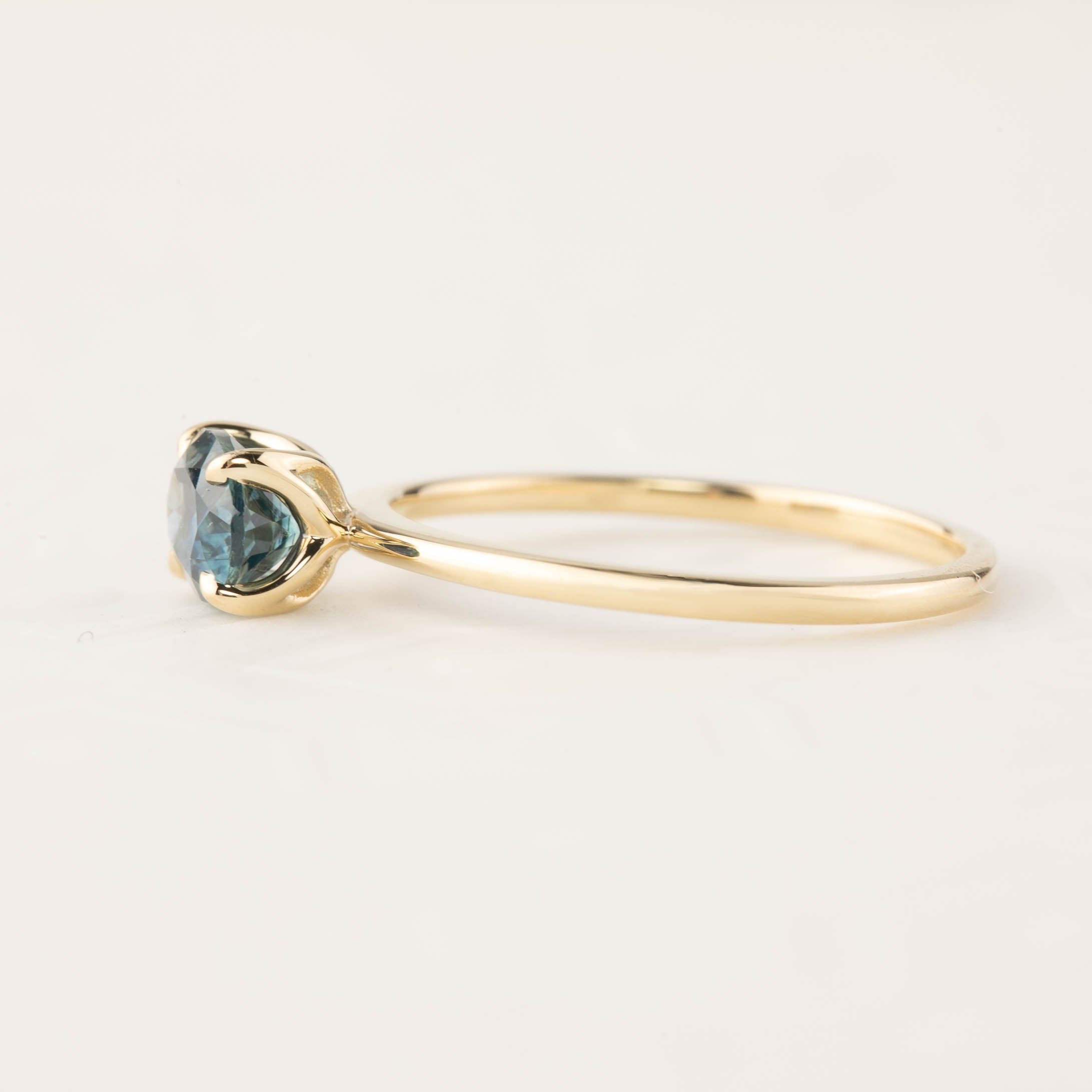 Sara Ring featuring 1.00ct blue green Montana sapphire set in 14k recycled yellow gold with a tapered band.