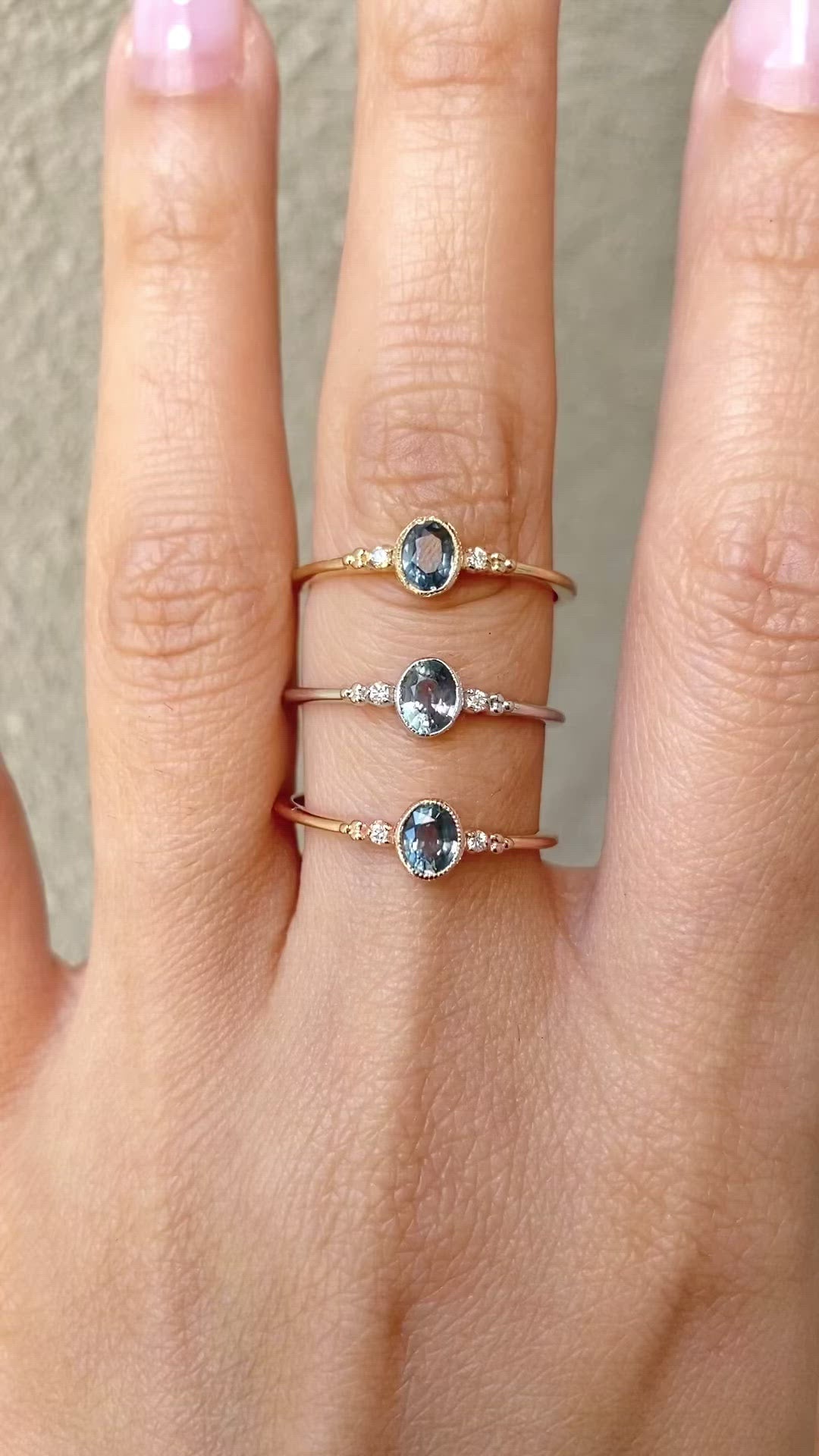 Three bezel set oval Madagascar sapphire ring with two natural diamond accents in a low profile 14k gold setting on the finger
