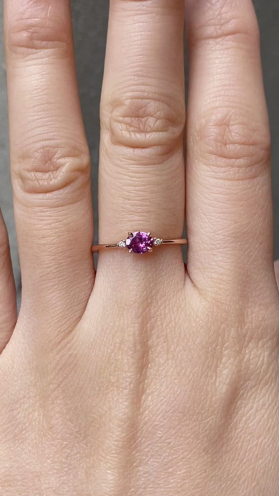The Emilie 0.45ct Umba pink sapphire ring worn to show the unique horizontal orientation and rose gold band on hand.