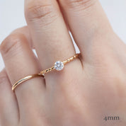 Hand wearing 14k yellow gold candy ring with 0.25ct round brilliant cut diamond in four prong flower setting