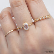 Close-up of hand wearing Ava Ring with oval rose cut diamond set in a delicate gold band with decorative bezel setting