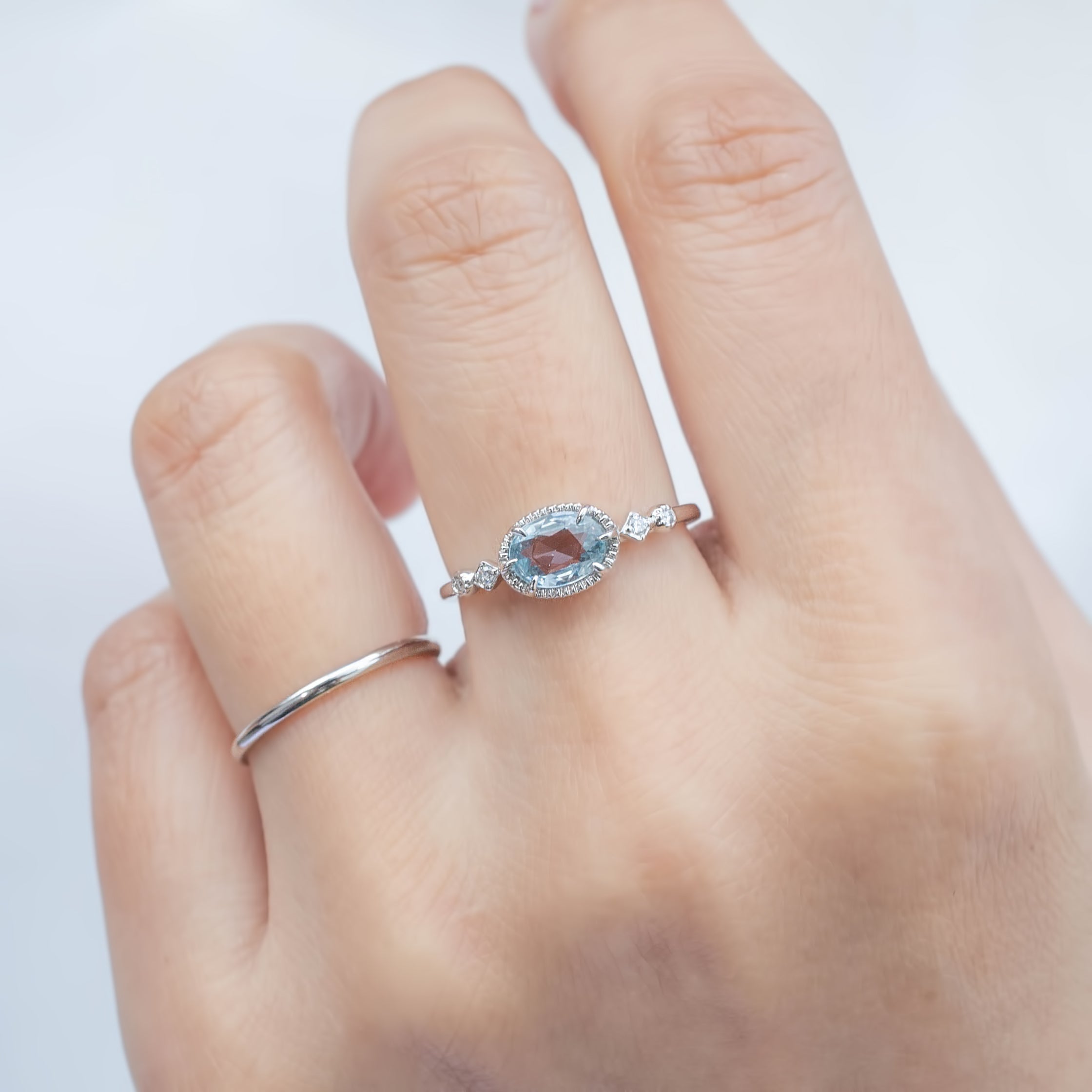 Close-up of hand wearing a 0.80ct unheated blue sapphire ring in 14k white gold with diamond accents