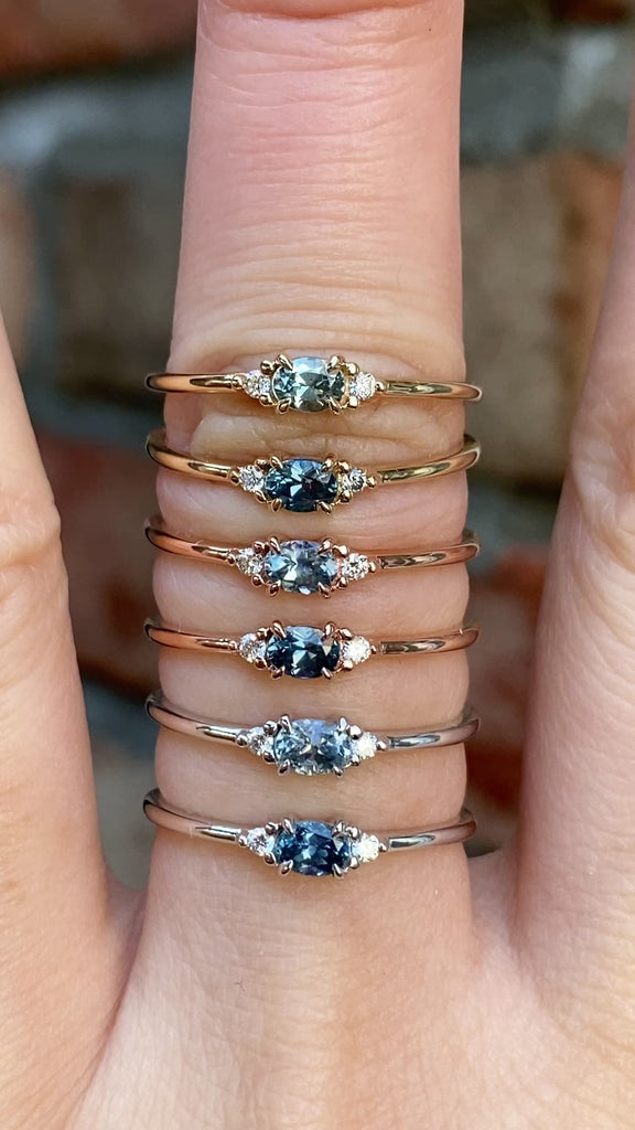 SIx different Emilie Rings featuring a 0.20ct East-West set oval Montana sapphire on the hand.
