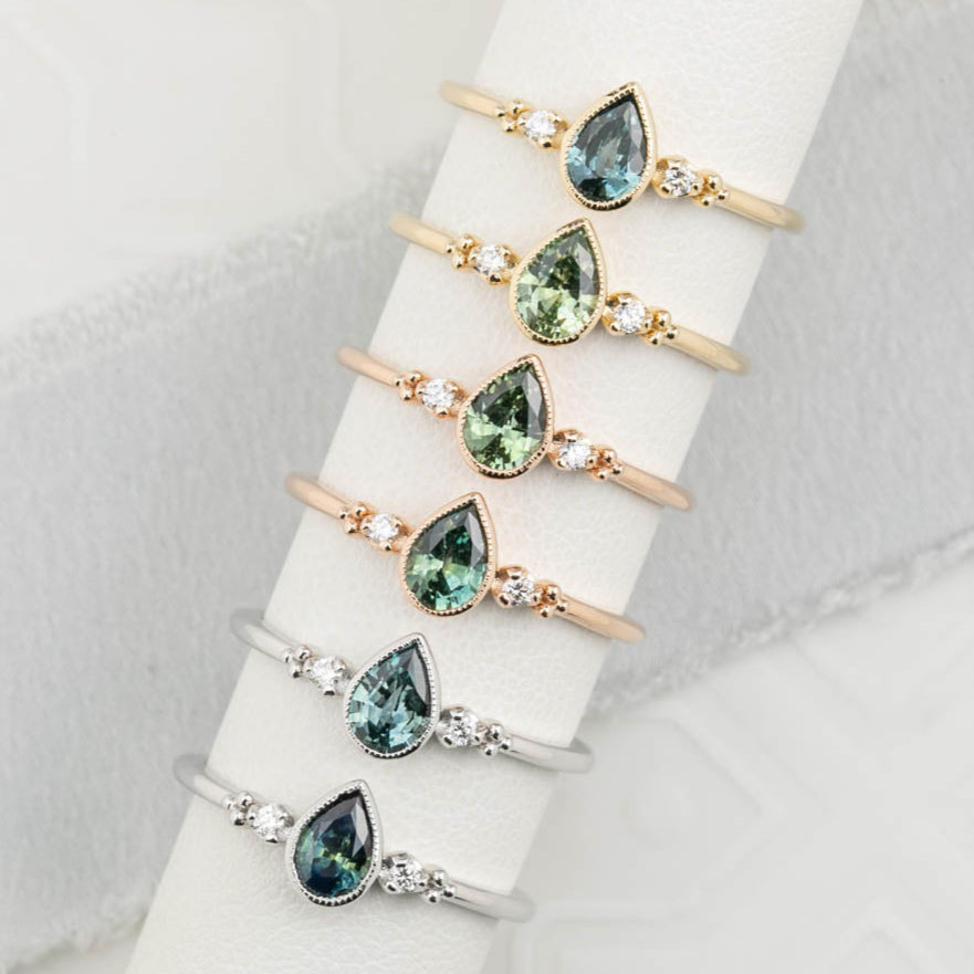 Estel Bezel Ring featuring a Pear Cut Montana sapphire and diamond accents. Low-profile 14k solid gold design. 6 ring options available.