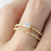 Close-up of a 0.25ct round brilliant cut diamond candy ring in 14k yellow gold worn on finger
