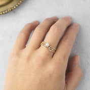 Hand wearing 14k yellow gold candy ring with 0.25ct round brilliant cut diamond and delicate band design