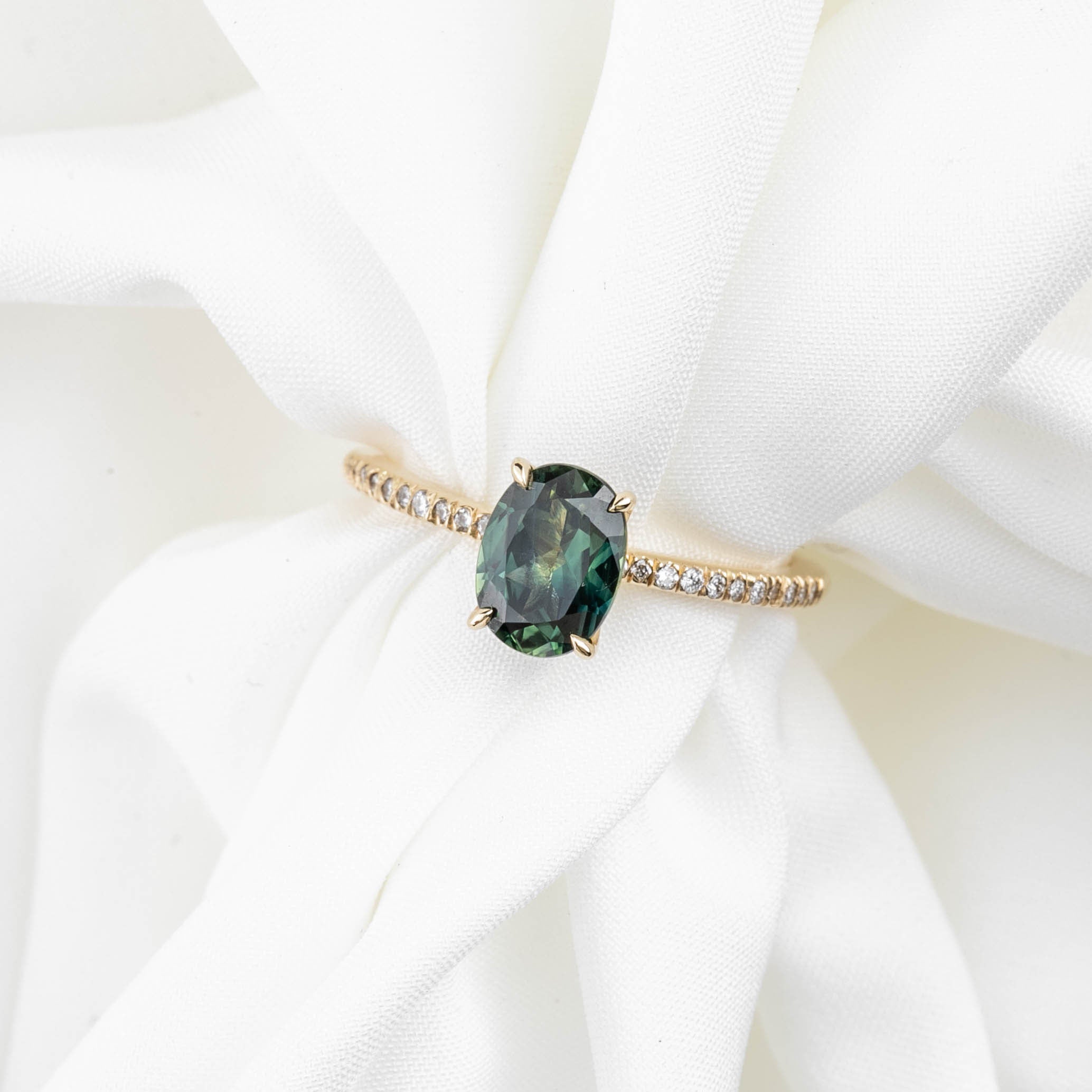 14k yellow gold ring with 1.53ct unheated oval green Queensland sapphire and small accent diamonds on band